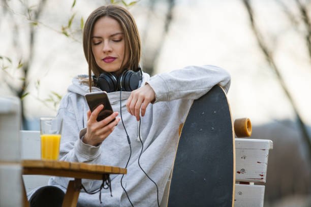 istock Female skateboarder typing on mobile 1137272205