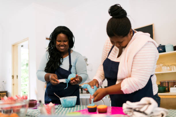 istock Two women piping cupcakes with icing 1137280738