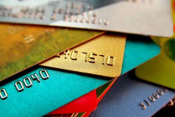 Photo of stack of multicolored credit cards, close up view with selective focus