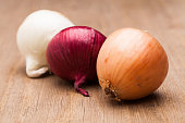 Three onions on wooden table