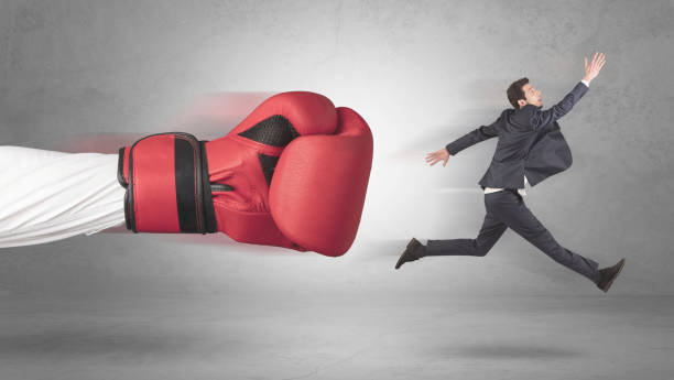 istock Businessman gets a hit from a giant hand 1137286849