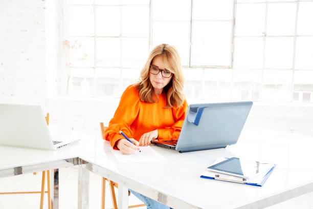 istock Businesswoman doing some paperwork while sitting at office desk and working 1137286974