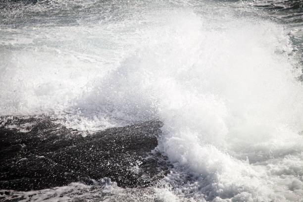 istock Wild sea and waves agains a rocky island 1137299548