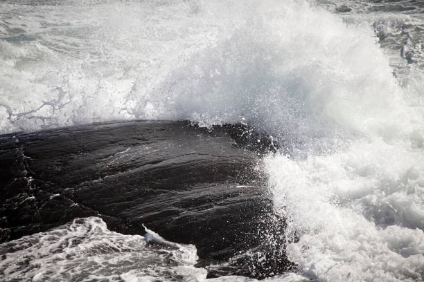 istock Wild sea and waves agains a rocky island 1137300040