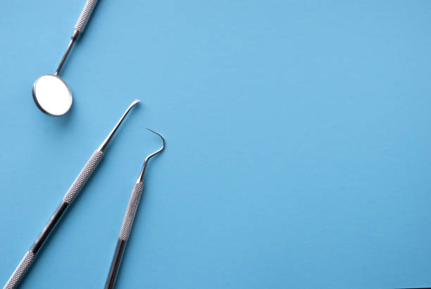 instruments dentaires sur le bleu. concept de soins dentaires. traitement dentaire. - dentist mirror orthodontist carver photos et images de collection
