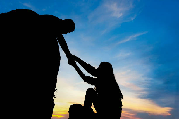 istock Teamwork couple helping hand trust assistance silhouette in mountains, sunset. 1137301064