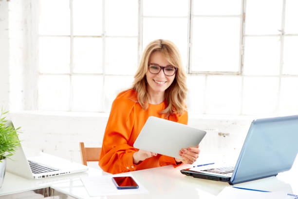 istock Businesswoman sitting at office desk and using her digitial tablet 1137303306