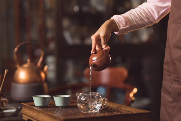 istock Women's hands pouring tea indoors 1137305378