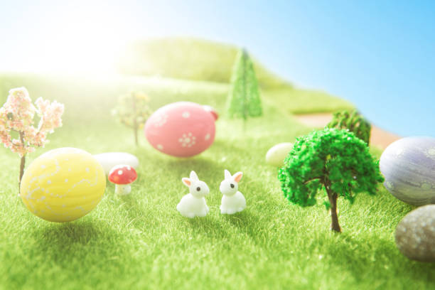 White and Gray Rabbit play with variety color easter egg on green grass