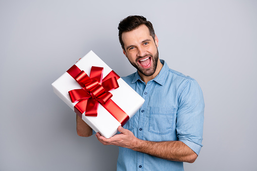 Close up photo amazing he him his guy romance surprise hold big large gift box scream shout yell girlfriend best boyfriend wear casual jeans denim shirts outfit clothes isolated grey background.