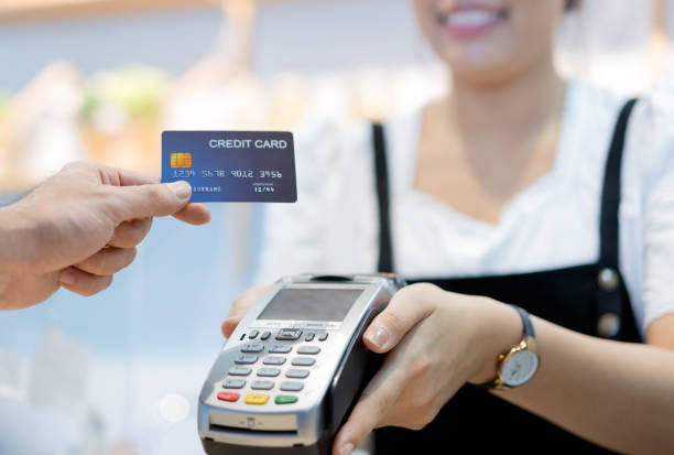 customer in cafe is paying via the credit card to shop assistant. customer in cafe is paying via the credit card to shop assistant asian cashier stock pictures, royalty-free photos & images
