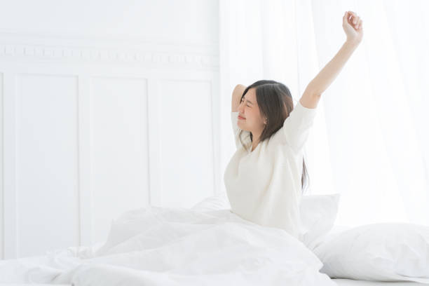 asian woman in the morning she stretching in her bed - stretching women attractive female indoors imagens e fotografias de stock