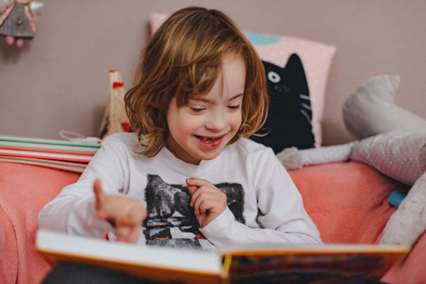 istock Little boy with down syndrome is reading a book. 1137312709