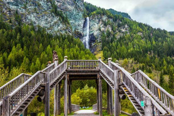 Picturesque waterfall among the cliffs of the High Tauern. The village Heiligenblut - southern starting point of the Grossglocknerstrasse road. Spring in the Austrian Alps. The concept of environmental and phototourism