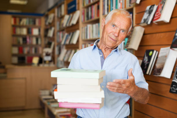 istock Elderly man holding books in bookstore 1137313408