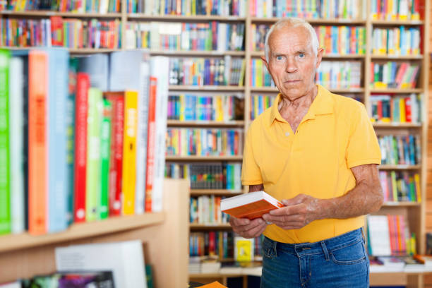 istock Focused elderly man looking for information in books in bookstore 1137313414