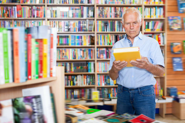 istock Focused elderly man looking for information in books in bookstore 1137313437