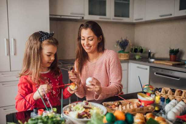 istock Mother and daughter decorating Easter eggs 1137313750