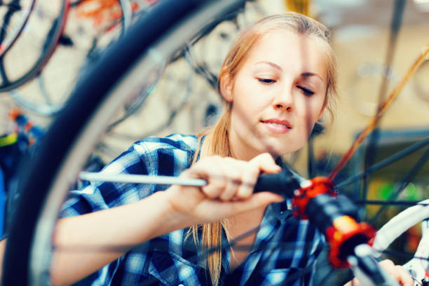 istock Young woman master is repairing bicycle in workshop. 1137315797