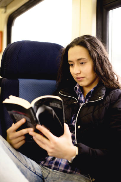 istock Young woman is reading the book on fast train 1137316050