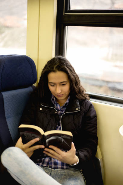 istock Young woman is reading the book on fast train 1137316298