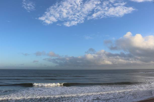 istock Fluffy white clouds in blue sky over coastline and beach with copy space 1137317743