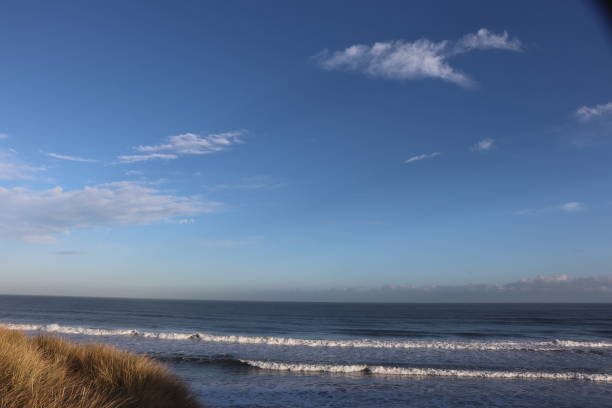 istock Fluffy white clouds in blue sky over coastline and beach with copy space 1137317882
