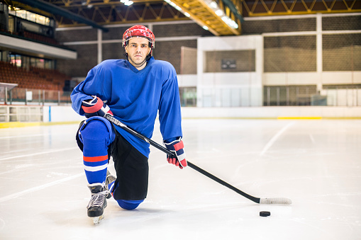 Ice hockey player at an ice hockey rink, holding a hockey stick. About 25 years old, Caucasian male.