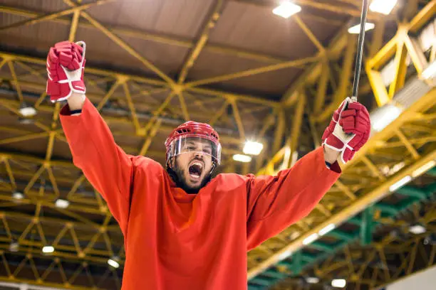 Ice hockey player at an ice hockey rink, celebrating a goal. About 25 years old, Caucasian male.
