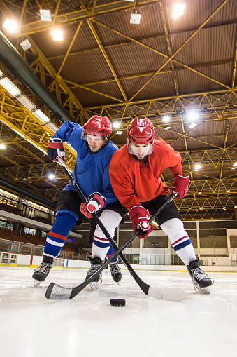 Ice hockey players at an ice hockey rink, during a match. Both about 25 years old, Caucasian males.