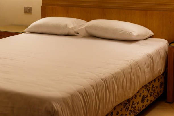istock Double bed with two pillows in bedroom in soft lights 1137322352