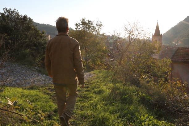 istock Mature man hikes above village at sunrise 1137323040