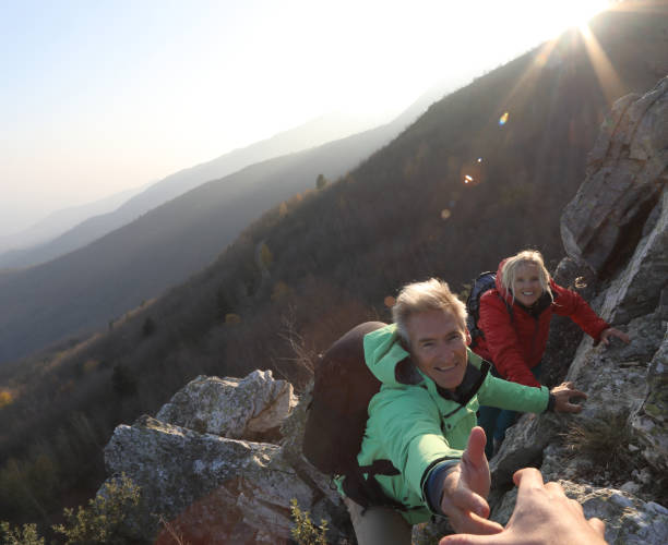istock View past helping hand to couple climbing up rock bluff 1137323246