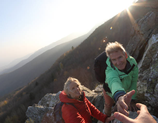 istock View past helping hand to couple climbing up rock bluff 1137323313