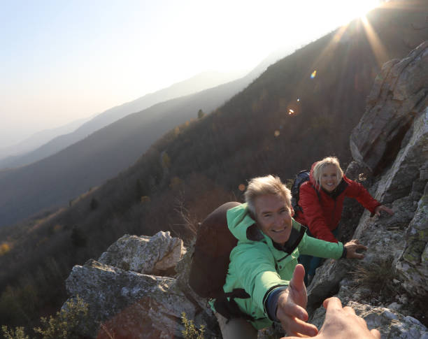 istock View past helping hand to couple climbing up rock bluff 1137323332