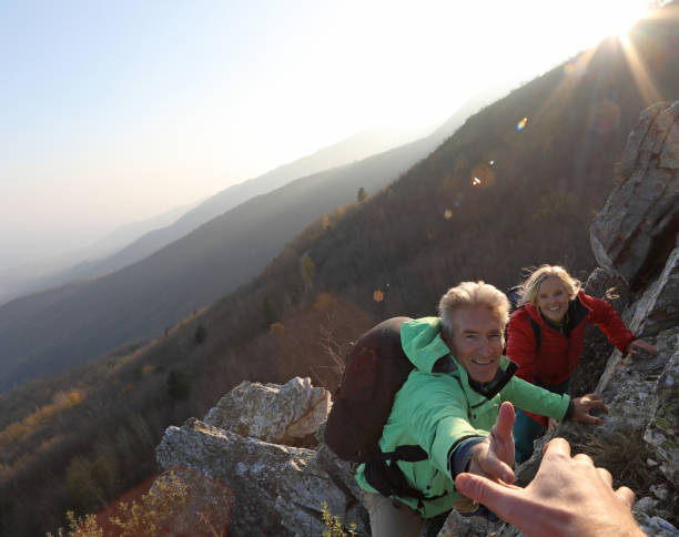istock View past helping hand to couple climbing up rock bluff 1137323608