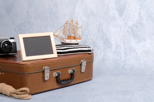istock old fashioned leather suitcase, picture frame with blank black space for text, sailboat toy, retro photo camera, rope. Clothing and personal accessories of sailor, nautical and marine style concept 1137324287