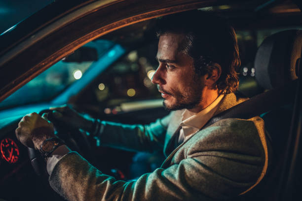 istock Man driving a car in city at night 1137324946