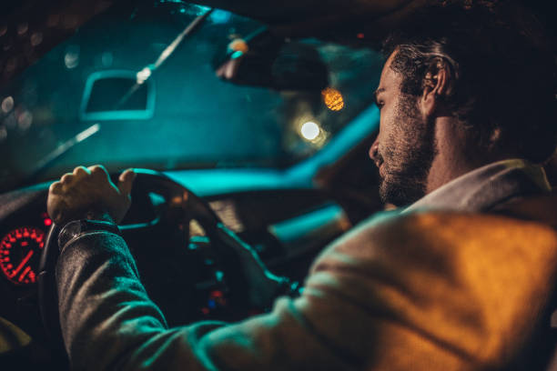 istock Handsome gentleman driving a car at night 1137325260