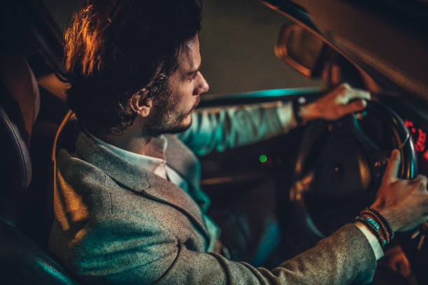 istock Modern man driving a car in city at night 1137325599