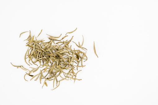 Silver needles white tea leaves or Baihao Yinzhen (Camelia sinensis) on a white background