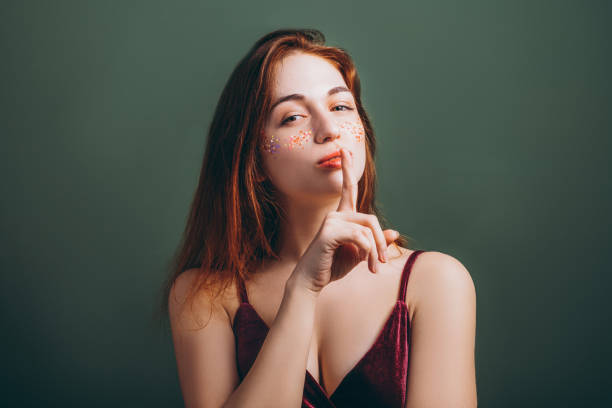 istock shh silence female finger lips fixed gaze 1137325877
