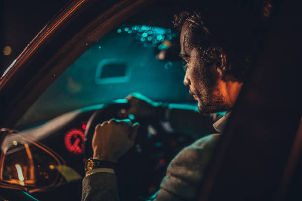istock Modern gentleman driving a car at night 1137327767