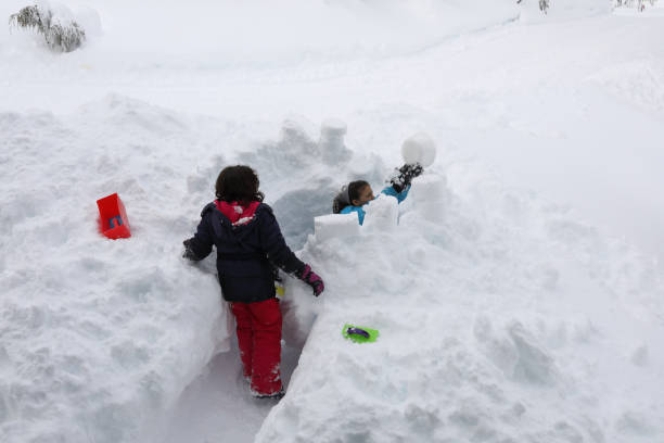 istock Mixed race girls build fort in deep snow 1137328044