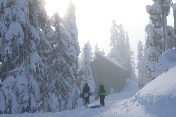 Two women return from the ski hill with sleigh and snowboard