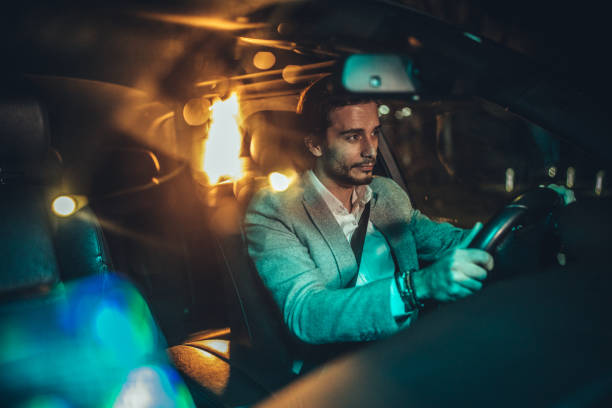 istock Gentleman driving a car at night 1137328218