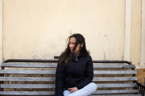 istock Young woman sitting on bench looking for the train 1137328305