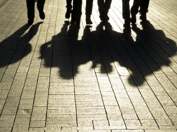 silhouettes et ombres de personnes dans la rue - gangster photos et images de collection