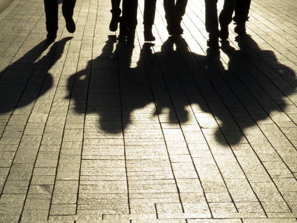 People silhouettes and shadows on the street Crowd walking down on sidewalk, concept of strangers, crime, society, street gang gang photos stock pictures, royalty-free photos & images