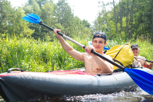 istock Rowing in kayak at weekend. Happy guys paddling during river rafting. Kayaking 1137332838